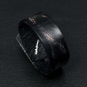Retro punk black leather cuff bracelet with distressed bronze patterns and white stitching