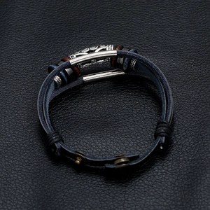 Detail of woven leather bracelet with alloy beads, wooden charms and snap buttons