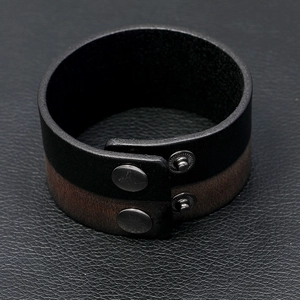 Detail of dual-tone leather bracelet featuring textured grain and metal snap buttons