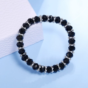 Pulsera de cuentas de cristal negro facetado y espaciadores plateados en expositor