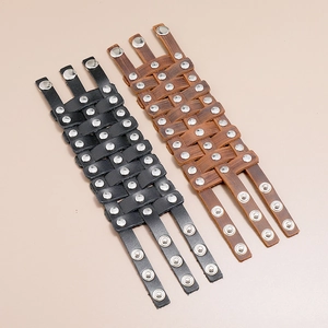 Detail view of woven leather bracelets in black and brown with silver metal studs