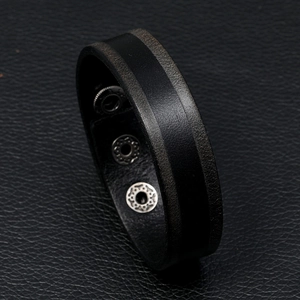 Detail van vintage zwarte lederen armband met drie zilveren verstelbare drukknopen