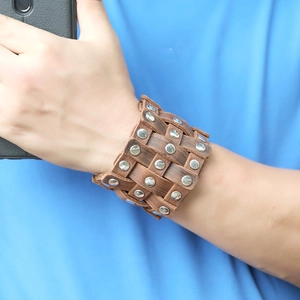 Vintage brown leather woven bracelet for men featuring silver studs and punk style