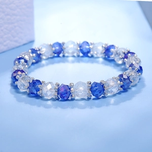 Primer plano detallado de cuentas de cristal azul y plateado en pulsera elástica
