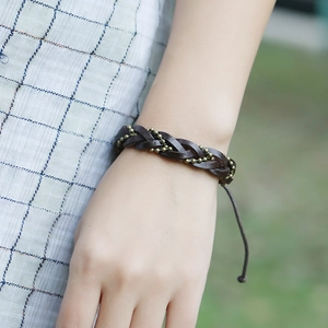 Vintage woven leather bracelet with brass beads and adjustable cord on a model wrist
