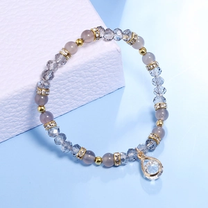Detail of beaded bracelet with grey crystals, golden accents and a water-drop pendant
