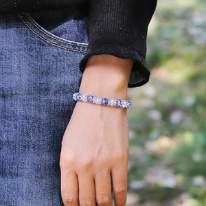 Pulsera elástica de mujer con cuentas de cristal azul y transparente puesta en la muñeca