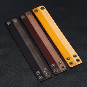Close-up of three premium leather bracelets in brown and tan with adjustable metal snaps