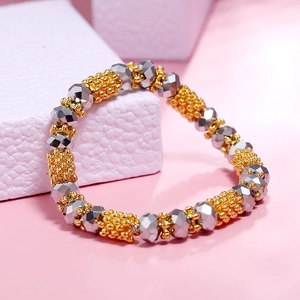 Minimalist elastic beaded bracelet featuring textured gold and faceted silver beads