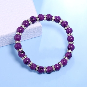 Detail van paarse marmeren kralenarmband met fonkelende kristallen tussenstukken op blauw