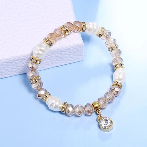 Detalle macro de pulsera con perlas, cristales y separadores dorados incrustados con diamantes