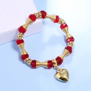 Detail of bohemian red crystal beaded bracelet with gold heart pendant and spacers