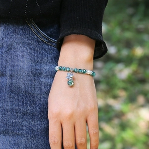 Böhmisches Perlenarmband mit grünen Kristallperlen und Silber-Schmetterling am Handgelenk