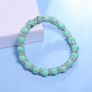 Macro-opname van turquoise kralenarmband met zilveren strass-tussenstukken en textuur