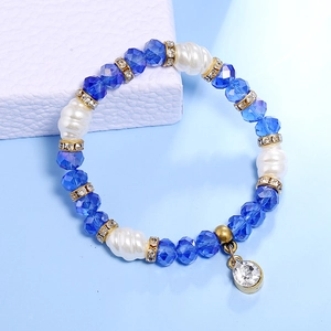 Detalle de cuentas de cristal azul y perlas barrocas blancas en una pulsera elegante