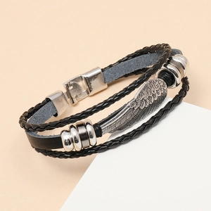Macro detail of multi-layer braided leather bracelet with silver feather charm and clasp