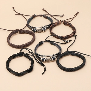 Close-up of six-piece vintage leather bracelets with braided rope and metal charms