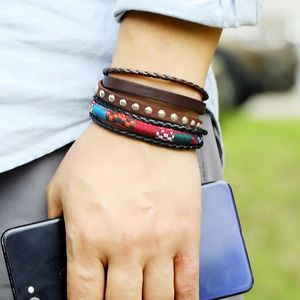Gros plan de bracelets bohèmes multicouches en cuir avec tissu ethnique tissé et clous