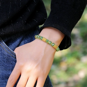 Minimalist elastic beaded bracelet with emerald green crystals and textured gold beads