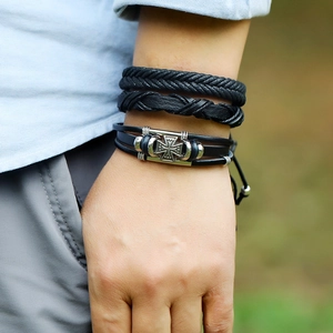 Detail shot of multi-layer black braided leather bracelets with alloy cross charm