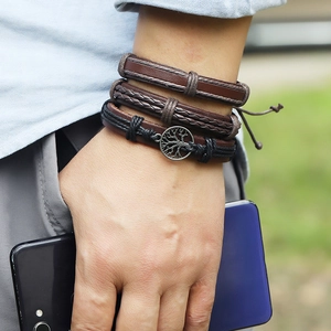 Détail de bracelets multicouches en cuir avec pendentif arbre de vie sur un poignet