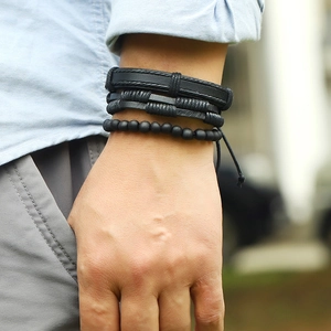 Close-up of black multilayer leather bracelets and matte beads on a male model wrist