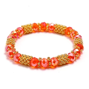 Elastic handmade bracelet with orange faceted crystal beads and gold metal accents