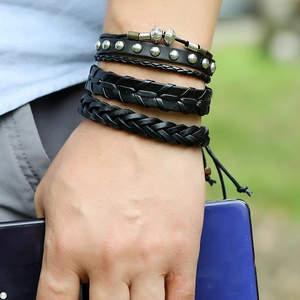 Close-up of four-piece layered black leather woven bracelet set for men on a wrist