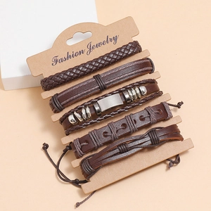 Vintage-Set aus braunen Lederarmbändern mit gewebten Bändern und Metallanhängern auf Karte