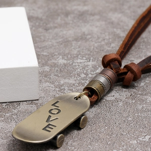 Vintage bronze skateboard pendant necklace with LOVE engraving and adjustable brown leather cord