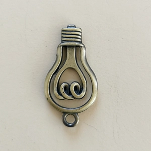 Detailed view of vintage bronze Edison bulb metal pendant for DIY jewelry and keychains