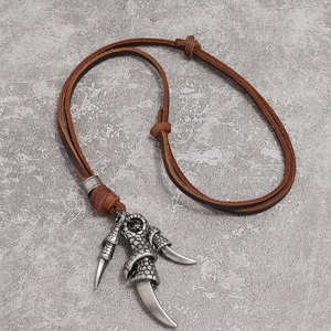 Retro punk claw pendant necklace with adjustable brown leather cord on stone background