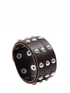Vue détaillée du bracelet large en cuir punk marron avec des clous en métal argenté et pressions