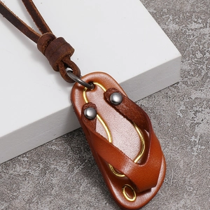 Macro detail of leather flip-flop pendant with metal rivets and yellow stitching