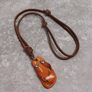 Vintage cowhide leather necklace featuring creative flip-flop pendant on stone background