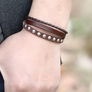 Retro multi-layer brown braided leather bracelet set with metallic stud accents on wrist