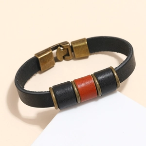 Detail of vintage black leather bracelet featuring cylindrical beads and bronze metal clasp