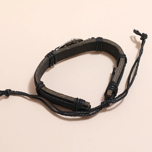Détail du bracelet réglable en cuir tressé noir avec breloque hibou en métal