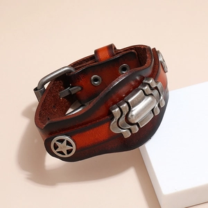 Detail of vintage multilayer brown leather bracelet with star studs and wave texture metal
