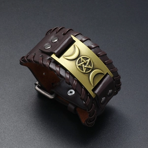 Detail eines Vintage-Lederarmbands mit geflochtenen Kanten und Messing-Pentagramm-Symbol