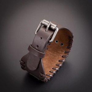 Detail of dark brown leather viking bracelet with stitched edges and silver metal buckle