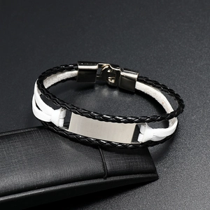 Détail du bracelet en cuir tressé multicouche avec plaque en métal argenté polie à graver