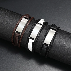 Détail de bracelets multicouches en cuir tressé avec plaque métallique gravable