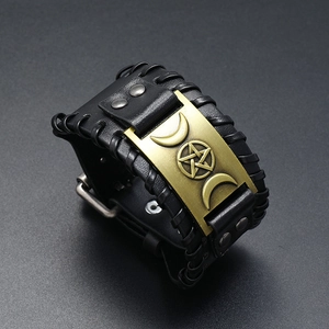 Makroaufnahme von schwarzem Lederarmband mit graviertem Mondphasen- und Pentagramm-Metallelement