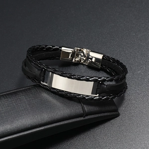 Gros plan d'un bracelet en cuir tressé multicouche pour homme avec plaque en métal