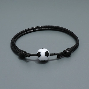Geflochtenes Fußball-Fan-Armband mit schwarz-weißer Fußball-Perle auf dunklem Grund