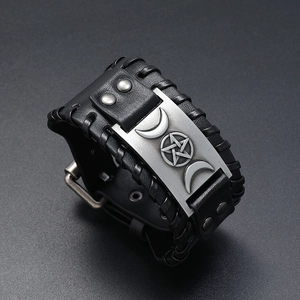 Nahaufnahme eines breiten schwarzen Punk-Lederarmbands mit silberner Dreifachmond-Metallplatte