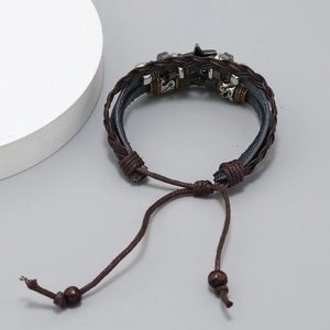 Detail of multi-layer braided leather bracelet with star charm and bead drawstring