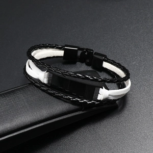 Détail du bracelet en cuir tressé multicouche avec plaque d'identité en métal noir poli