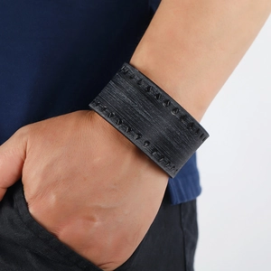 Vintage punk black leather wide cuff bracelet with rivet detailing worn on wrist